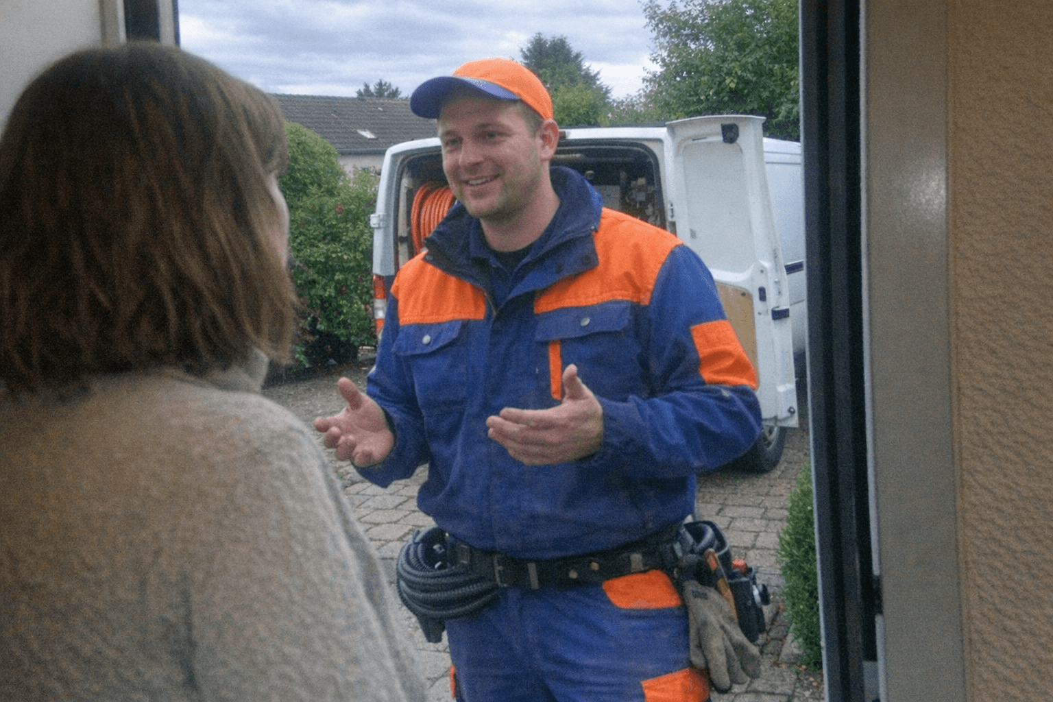 Hand hält ein Tablet mit Leistungspositionen und Zeitstempeln, im Hintergrund steht ein Werkzeugkoffer